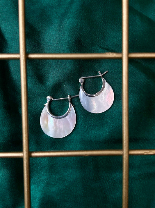 Pair of shell hoop earrings with a green fabric background, silver earrings, jewelry