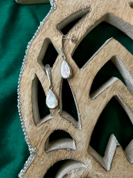Teardrop-shaped earrings on a wooden decorative piece, pearl drop earrings, silver earrings,