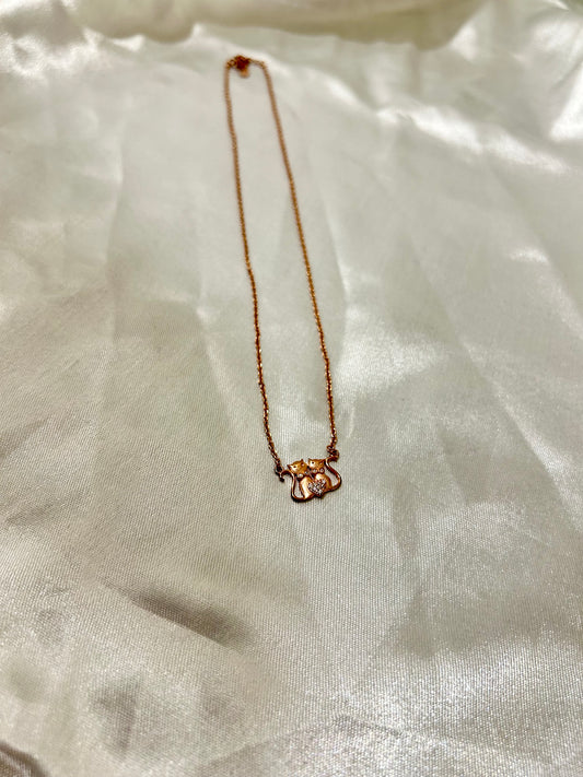 Necklace with a small pendant on a light fabric background, rose gold cat necklace, jewelry for women,