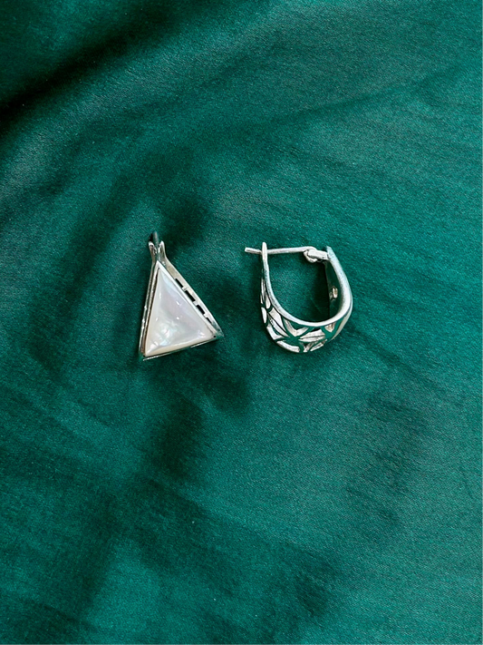 two silver earrings in a teal background, pearlux hoops, earrings,